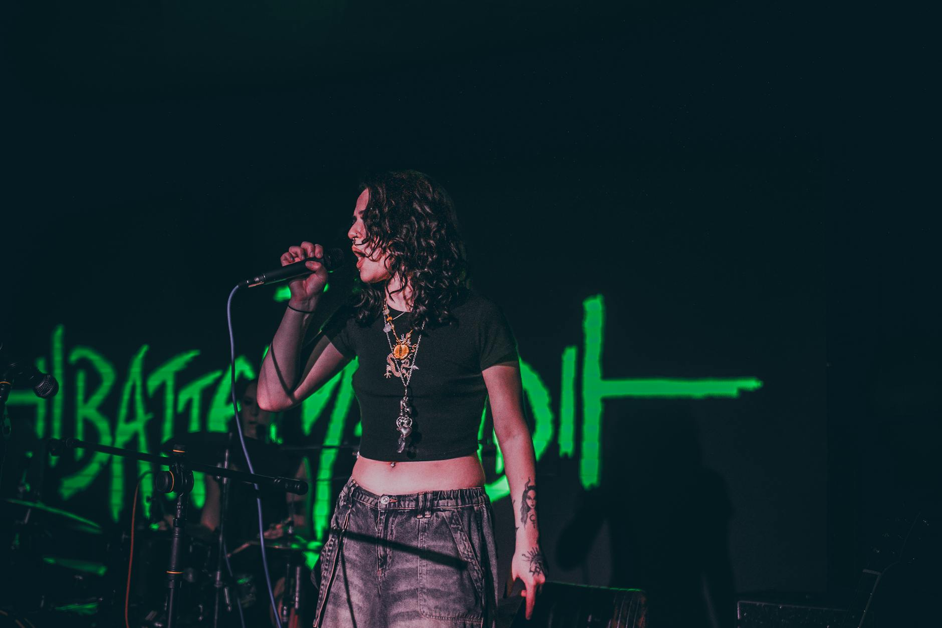 Capture of a woman passionately singing at a live music concert.